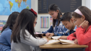 Niñas y niños leyendo libros en la escuela